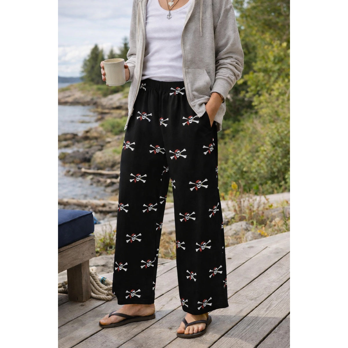 model wearing The Naughty Angler Pirate Pant loungewear featuring cross scull and bone pirate with a red bandana, on a black pant.